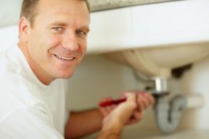 a Santa Clara Plumbing pro tightens a leaky sink drain with a pipe wrench